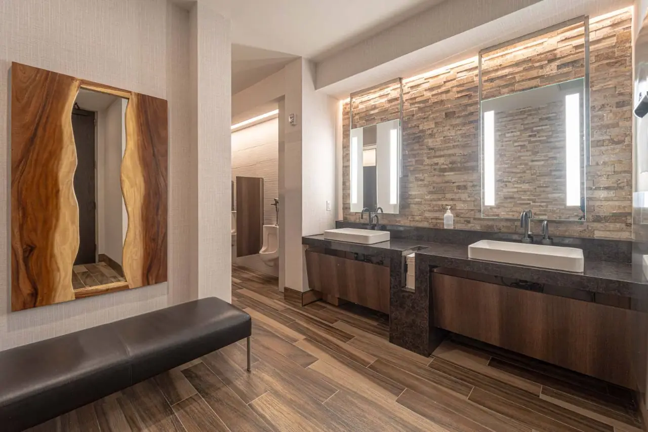 Executive restroom with stone tile and accent lighting